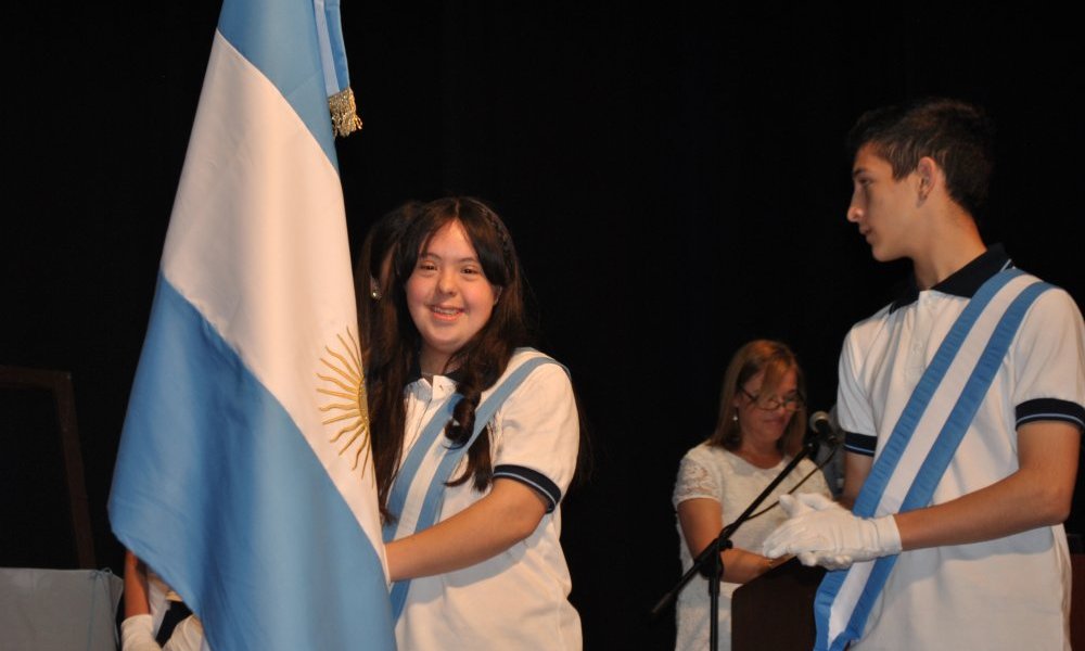 Florencia Ledesma Candás, lleva la bandera nacional de la Escuela Normal